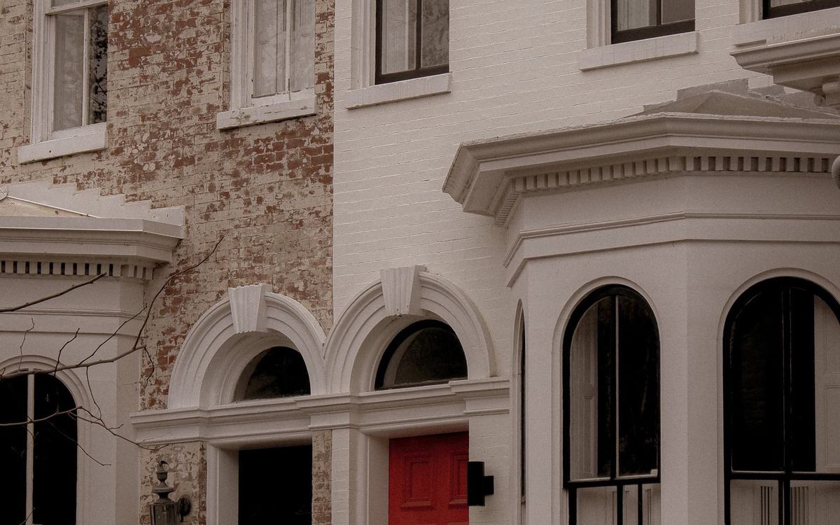 White painted frontage of a period terraced house with bay windows